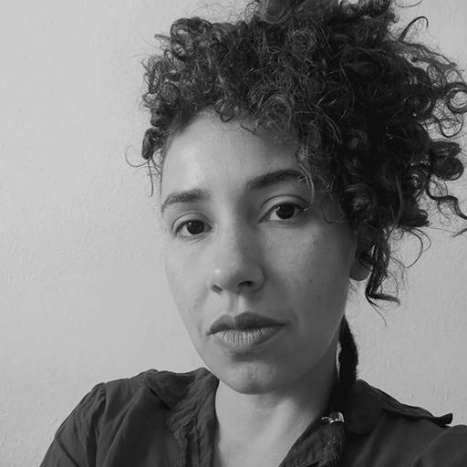 Uma mulher com cabelo preso acima da cabeça olhando séria